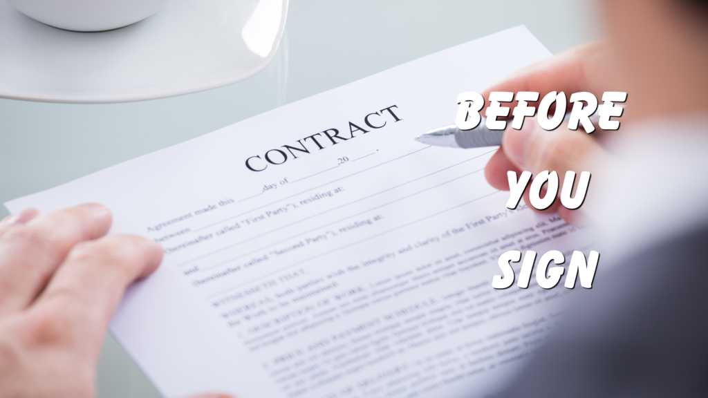 A person's hands holding a contract document and a pen, with a coffee cup in the background.