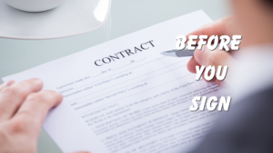 A person's hands holding a contract document and a pen, with a coffee cup in the background.