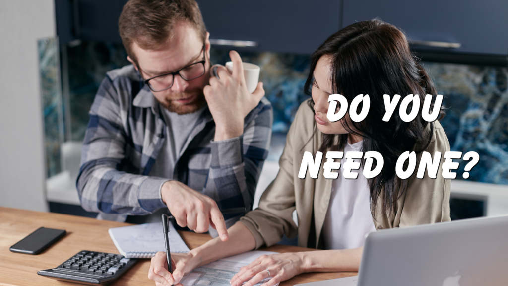 A person points at an estimate while another person writes on it, with a laptop and calculator on the table.